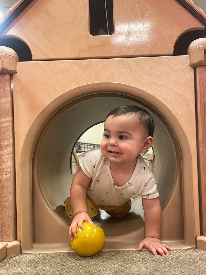A child exploring the indoor play structure at Paché Montessori
